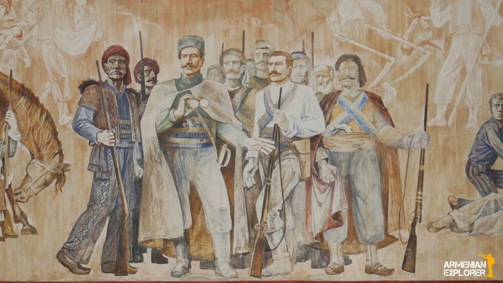 Pintura tipo mural de fedayi armenios con vestimenta de finales del XIX o inicios del XX, fusiles y figura central con prismáticos; sombras de más combatientes y caballos al fondo.