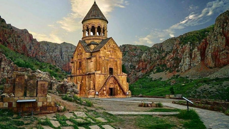 Iglesia Surb Astvatsatsin de Noravank: escalera de piedra en voladizo hacia la planta superior, cruz tallada bajo la cúpula, khachkares y desfiladero.